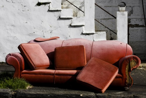 Charity volunteers collecting reusable furniture from a skip